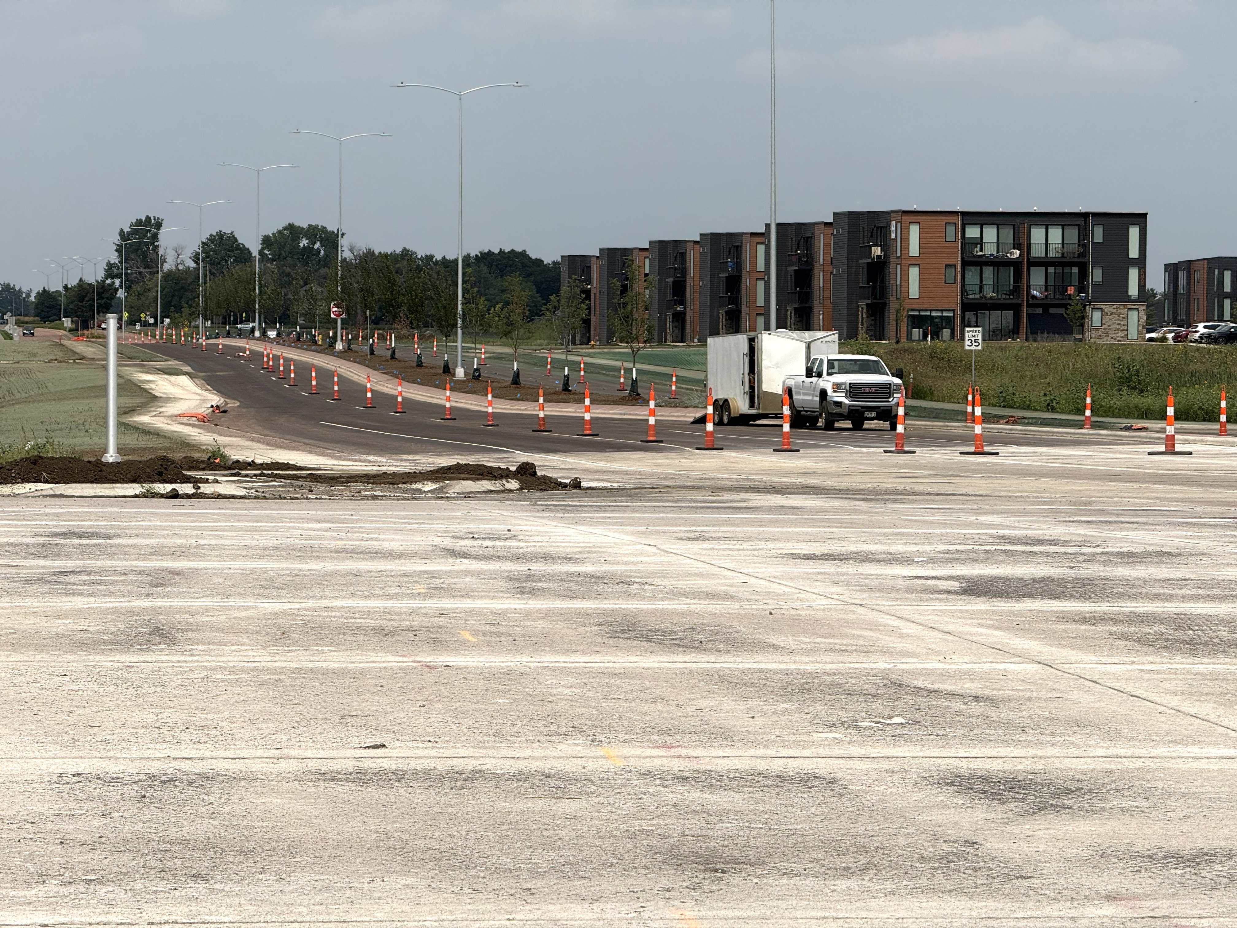 Newly opened Southeastern Avenue, including completed roadway pavement, streetlight poles, hydroseeded slopes, and ongoing landscaping work along the corridor.